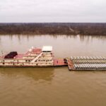 un-grand-bateau-flottant-au-dessus-dune-riviere-a-cote-dun-quai-El6lIjXN-fI